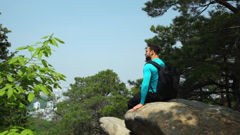 Man-Backpacker-resting-on-top-of-Gwanaksan-mountain-in-Central-Seoul---popular-korean-trekking-and-hiking-trail