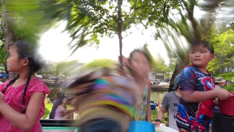 Feliz-Joven-Tailandesa-Vertiendo-Agua-A-La-Cámara-Desde-Un-Cubo-Durante-El-Festival-Songkran