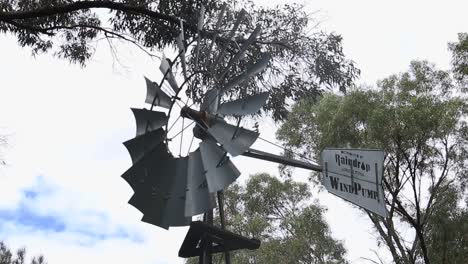 Nahaufnahme-Einer-Traditionellen-Australischen-Landwirtschaftswindpumpe-Mit-Sich-Drehenden-Rotorblättern