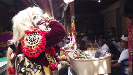 Der-Maskierte-Topeng-Tänzer-Bereitet-Sich-Mit-Perücke-Und-Blumen-In-Einer-Traditionellen-Hinduistischen-Balinesischen-Zeremonie-Auf-Bali,-Indonesien,-Mit-Farbenfrohem-Outfit-Auf-Sein-Tanzdrama-Vor