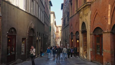 Walking-through-the-cobbled-medieval-streets-of-Siena,-Provence-of-Siena,-Italy