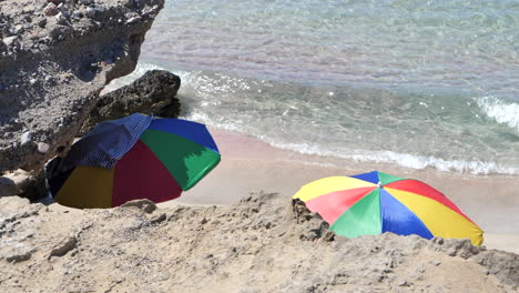 Colorful-beach-umbrellas-on-deserted-beach.-Slomo,-static