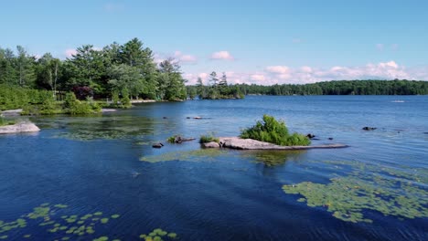 Forward-and-low-over-tiny-rock-island-on-Big-Bald-Lake-in-cottage-country-Trent,-Ontario