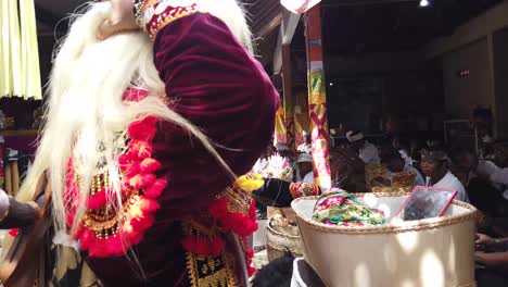 Masked-Dancer-Performs-Topeng-Theater-Ritual-in-Balinese-Hindu-Ceremony,-wears-a-Carved-Mask-and-Blonde-Wig-for-Cleaning-and-Purification-Traditions