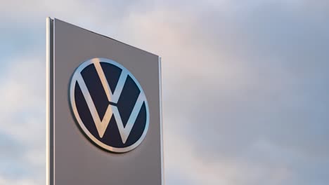 Car-dealership-sign-against-cloudy-sky.-Volkswagen.-Time-lapse