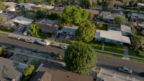 Aerial-overview-of-suburban-Los-Angeles-neighborhood,-street-with-cars,-pool
