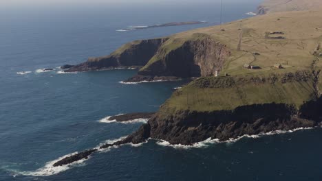 Filmischer-Drohnenflug-Entlang-Der-Küste-Auf-Der-Insel-Sudroy,-Akraberg,-Dem-Südlichsten-Punkt-–-Leuchtturm-Am-Rand-Einer-Klippe-Bei-Sonnenlicht