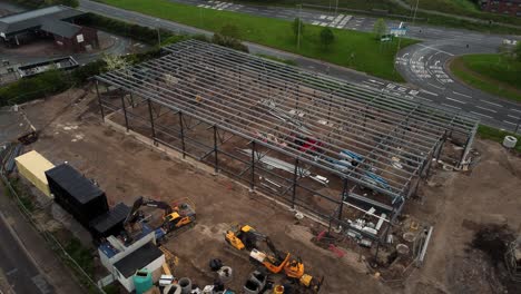 ALDI-supermarket-construction-building-site-aerial-view-circling-industrial-framework-development,-UK