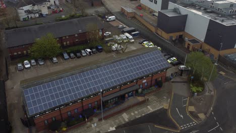 Widnes-town-police-station-with-solar-panel-renewable-energy-rooftop-in-Cheshire-townscape-aerial-descending-Birdseye-view