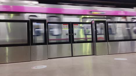 Tren-De-Metro-Que-Se-Mueve-Rápidamente-Cruzando-La-Estación-De-Metro-Hasta-El-Destino-Por-La-Tarde-El-Video-Se-Toma-En-La-Estación-De-Metro-De-Hauz-Khas-Nueva-Delhi-India-El-10-De-Abril-De-2022