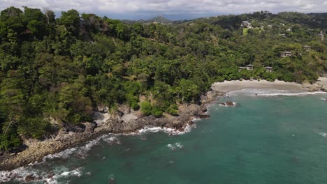 Drone-shot-flying-over-turquoise-water-towards-the-coast,-Manuel-Antonio,-Costa-Rica