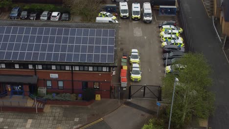 Vehicles-parked-outside-town-police-station-with-solar-panel-renewable-energy-rooftop-in-Cheshire-townscape-aerial-view
