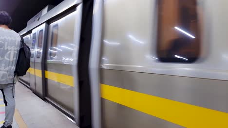Tren-De-Metro-Llegando-A-La-Estación-Con-Pasajeros-Esperando-Para-Abordar-El-Video-Fue-Tomado-En-La-Estación-De-Metro-De-Nueva-Delhi-Nueva-Delhi,-India-El-10-De-Abril-De-2022