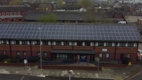 Widnes-town-police-station-with-solar-panel-renewable-energy-rooftop-in-Cheshire-townscape-aerial-view-dolly-left