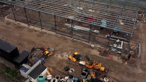 ALDI-supermarket-construction-building-site-aerial-view-tilting-up-to-industrial-power-station-skyline