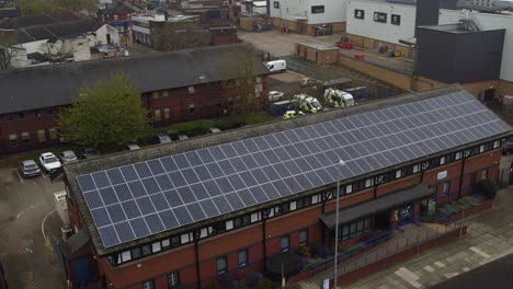 Aerial-view-circling-British-town-police-station-with-solar-panel-renewable-energy-rooftop-in-Cheshire-townscape