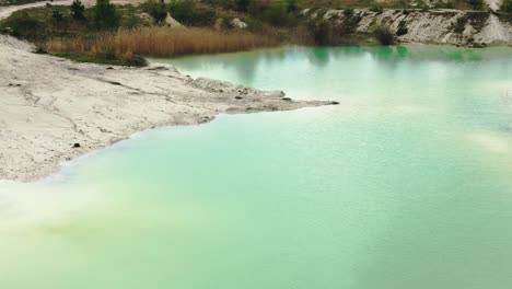 Drone-shot-of-a-lake-with-turquoise-water-in-an-abandoned-kaolin-quarry