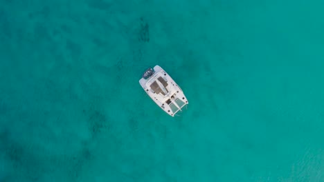Aerial-Top-Down-Drone-View-of-Bahamas-Deserted-Island-with-Solitary-Sailboat-and-Clear-Water