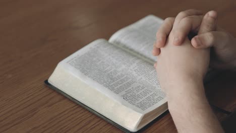 Mann-überreicht-Bibelbuch-Und-Gebet-Im-Haus-Des-Spirituellen-Glaubens,-Des-Heiligen-Evangeliums