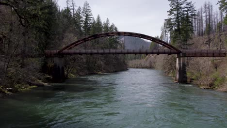 River-Bridge-in-Umpqua-National-Forest,-Douglas-County,-Oregon---Aerial-Flight-under-Bridge