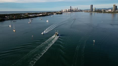 Aerial-over-the-Broadwater-on-the-Northern-end-of-the-Gold-Coast-following-a-trawler-moving-towards-Surfers-Paradise,-Queensland,-Australia-20230502