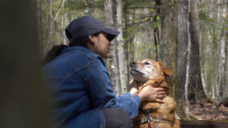 Pretty-young-diverse-woman-loving-petting-and-showing-love-to-her-adorable-senior-dog-in-the-woods-of-upstate-new-york