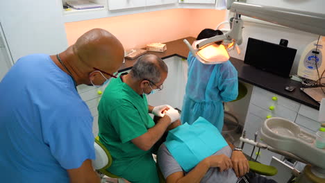 push-in-shot-showing-doctors-and-nurses-observing-a-dental-procedure-taking-place