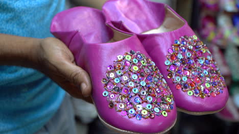 Stilvolle-Rosa-Belgha-Lederschuhe,-Die-Marokkanische-Handwerkskunst-Auf-Dem-Lebhaften-Alten-Medina-Markt-Von-Marrakesch-Präsentieren