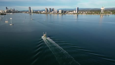 Circling-aerial-over-a-trawler-moving-towards-Surfers-Paradise-on-the-Broadwater-on-the-Northern-end-of-the-Gold-Coast,-Queensland,-Australia-20230502