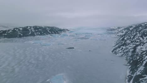Aerial-View,-Glacier-and-Glacial-Lake-Frozen-Water-and-Icebergs-on-Misty-Winter-Day