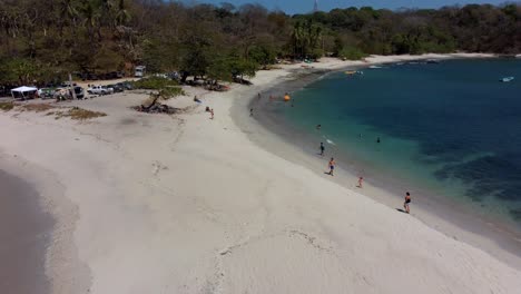 Beliebtes-Touristenziel-Am-Strand-Von-San-Juanillo-In-Costa-Rica-Mit-Türkisblauem-Meer-Und-Menschen,-Die-Die-Sonne-Genießen,-4K-Luftdrohne