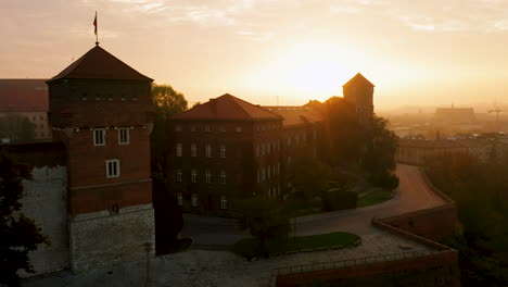 Drone-footage-of-front-of-Wawel-Royal-Castle-at-magic,-cloudy-dawn-with-soft,-morning-sunlight,-Krakow-,-Poland