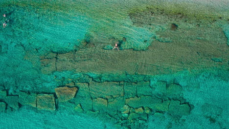 Top-down-view-of-swimming-man-in-sea-in-Hanioti-,-Greece