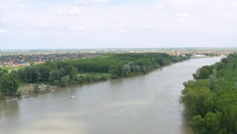 Aerial-shot-circling-around-the-Danube-River-near-Novi-Sad,-Serbia-on-a-bright-day
