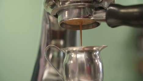 Low-angle-upward-view-of-coffee-dripping-through-portafilter-espresso-machine