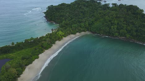 Sandy-Beach-Shore-Of-Manuel-Antonio-Caribbean-Island-Headland,-4K-Costa-Rica-Drone-Flyover