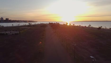 Aerial-drone-shot-revealing-the-beautiful-beach-while-sunset-with-a-walkway