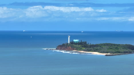 Telephoto-Drone-Flyover-Lighthouse-On-Island-With-Blue-Ocean-At-Point-Cartwright,-Australia-4K