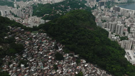 Aerial-top-down-circular-view-cityscape-rooftops-with-high-skyscrapers-and-apartment-buildings-surrounded-by-mountains