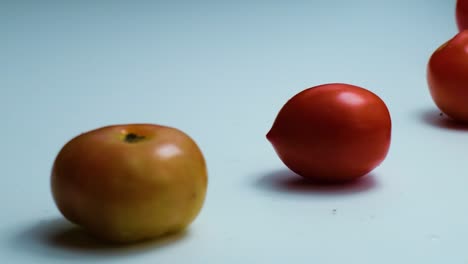 Slow-motion-clip-of-fresh-red-tomatoes-falling-on-white-background