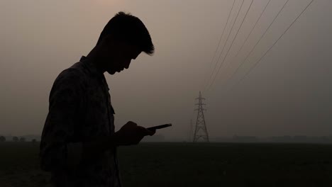 Ein-Kleiner-Südasiatischer-Junge-Benutzt-Abends-Ein-Smartphone