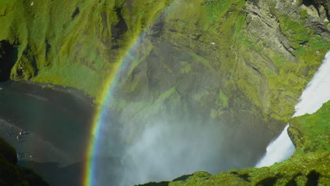 Von-Oben-Nach-Unten,-Zeitlupenaufnahmen-Des-Skogafoss-Wasserfalls-Mit-Regenbogen-–-Wasserfall-Am-Fluss-Skoga-In-Südisland