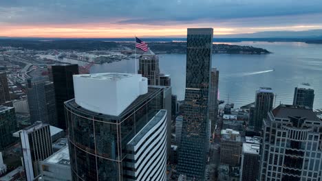 Drone-shot-of-a-flag-waving-high-over-Seattle's-downtown-corridor