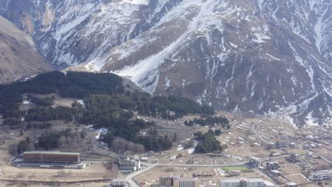 Rural-town-in-barren-winter-landscape-with-snow-mountain-kazbegi-stepmantsminda
