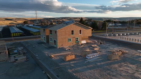 Drone-shot,-houses-under-construction,-sunset