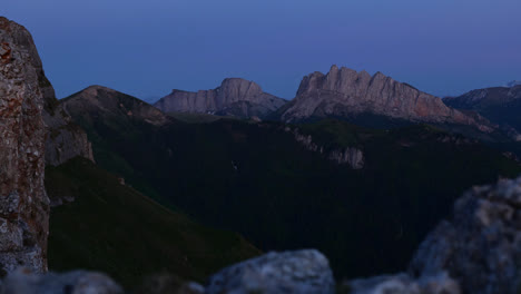 Blue-hour-view-of-sheer-granite-exposed-ridgeline-cliffs-with-rocky-foreground