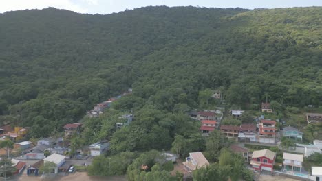 Los-Drones-Vuelan-Sobre-Las-Casas-De-Las-Colinas,-La-Playa-Y-El-Agua-De-Mar-De-Santa-Catarina,-El-Sur-De-Brasil,-El-Paisaje-Natural-Panorámico-En-El-Destino-Del-Viaje