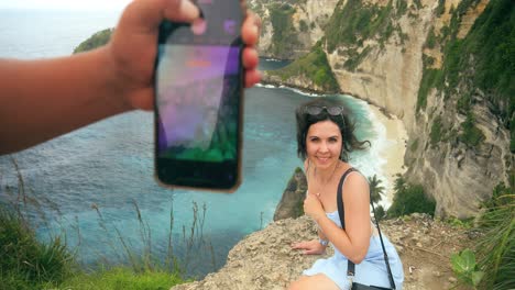 Medium-shot-of-a-beautiful-influencer-getting-her-picture-taken-at-the-iconic-Diamond-Beach-on-the-Island-of-Nusa-Penida-in-Bali,-slow-motion