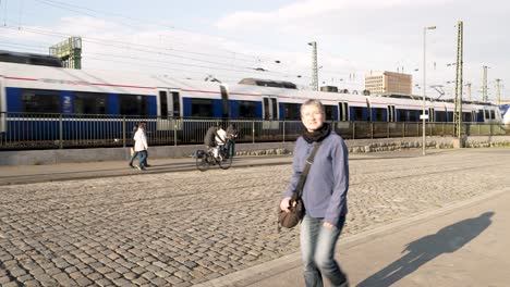 Vorbeifahrende-Regionalbahn-Mit-Einheimischen,-Die-Auf-Dem-Kopfsteinpflaster-Neben-Der-Hohenzollernbrücke-In-Köln-Vorbeigehen