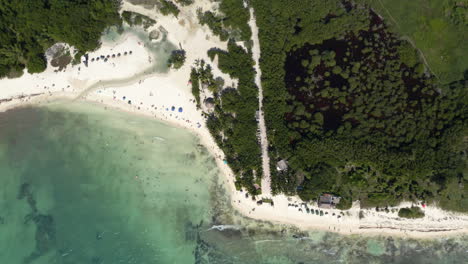 Touristic-white-sand-beach-and-tree-foliage-in-Punta-Esmeralda-bay